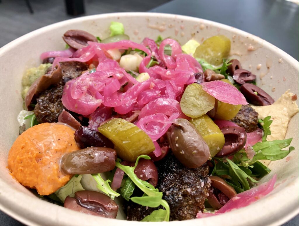 CAVA bowl: romaine, meatballs, spicy hummus, original hummus, eggplant, olives, pickles, vinaigrette, pickled onions