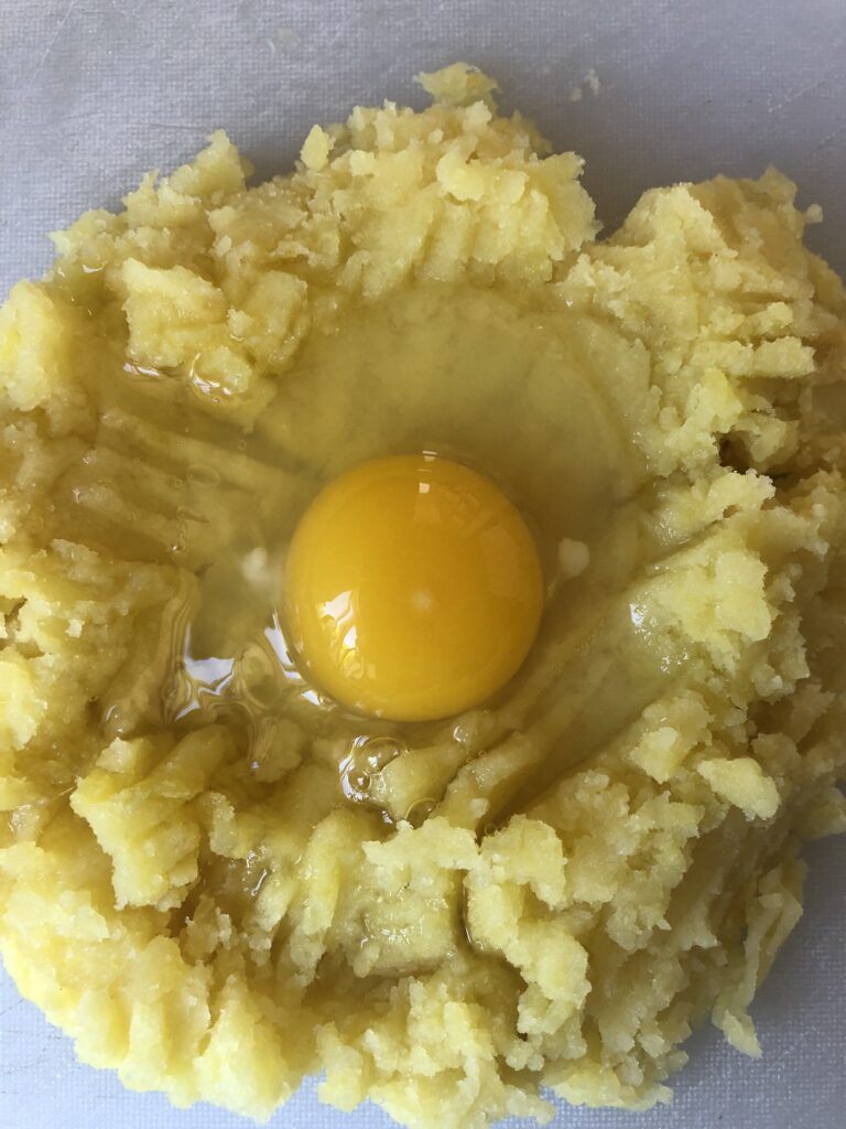egg in the middle of mashed potatoes